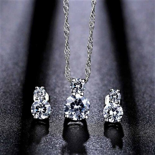 Set Doble ADELSTEN con Cadena, Dije y Aretes en Chapa de Rodio SWAROVSKI ELEMENTS INCLUYE DE REGALO ARETES DIAMOND Y CAJA PARA REGALO	