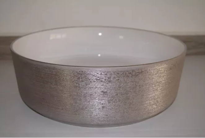 Lavabo Cerámico para Baño JAA, forma circular en color plata con detalles en relieve metalizados. De sobreponer, con diseño europeo ideal para todo tipo de baños. Dimensiones 36.0 x 36.0 x 12.5 cms. (base x altura x profundidad).