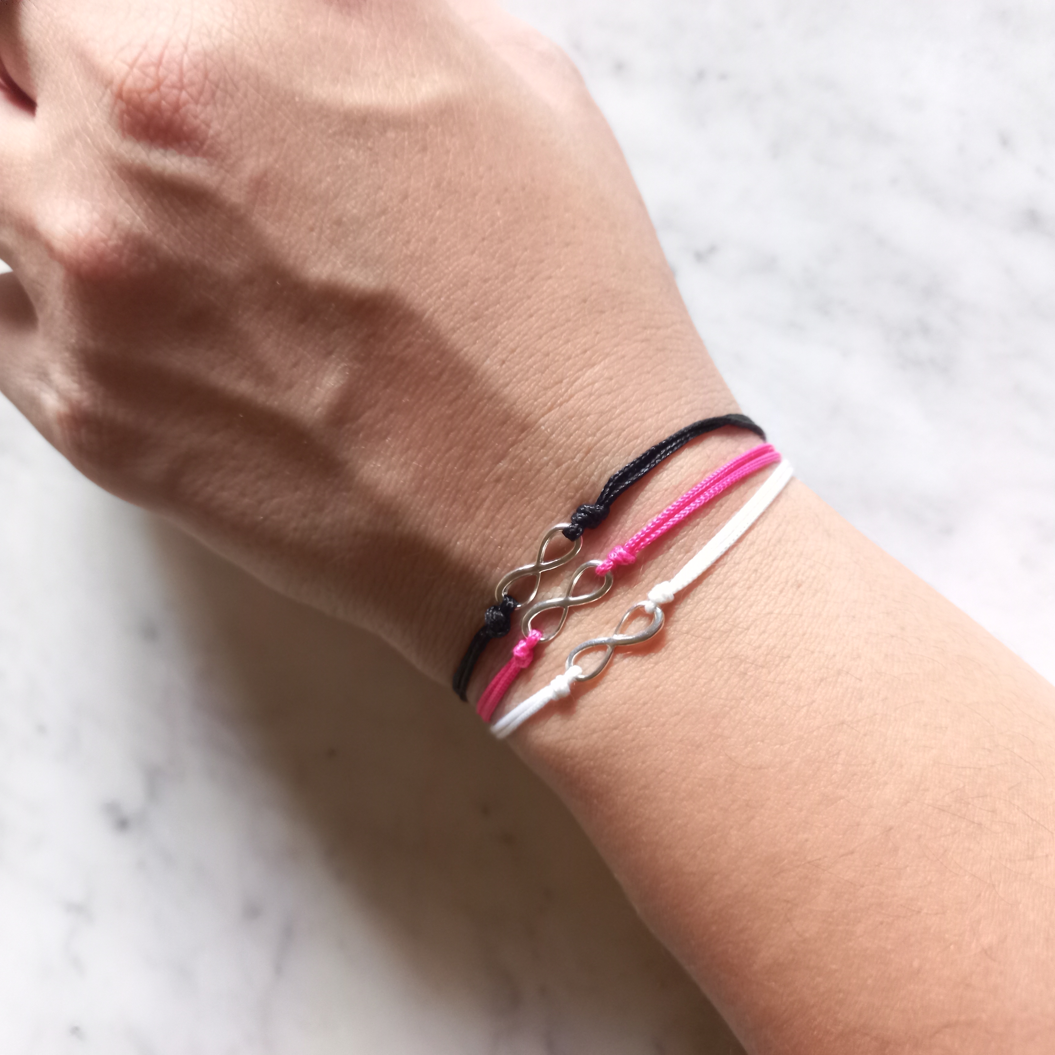 Set con 2 Pulseras de hilo con infinito de plata .925.