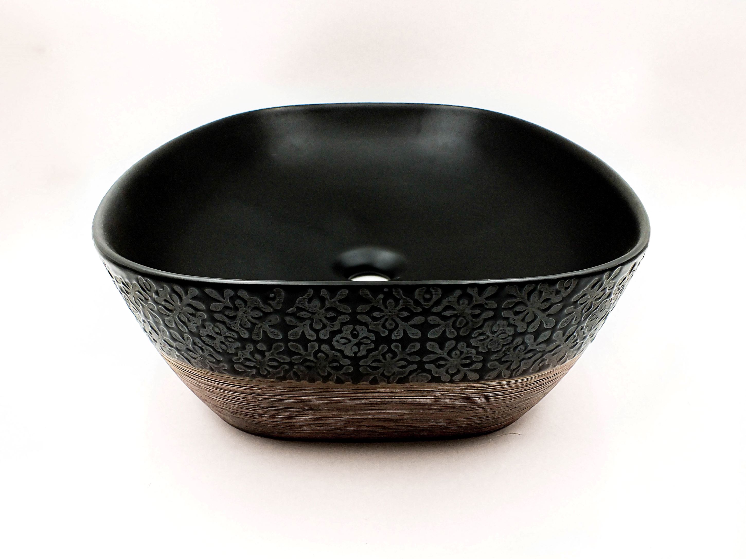 Lavabo Cerámico para Baño KOD, forma rectangular, color negro mate con acabados tipo madera y texturas en relieve. De sobreponer con diseño europeo ideal para todo tipo de baños. Dimensiones 50.5x39x13.5 cms.