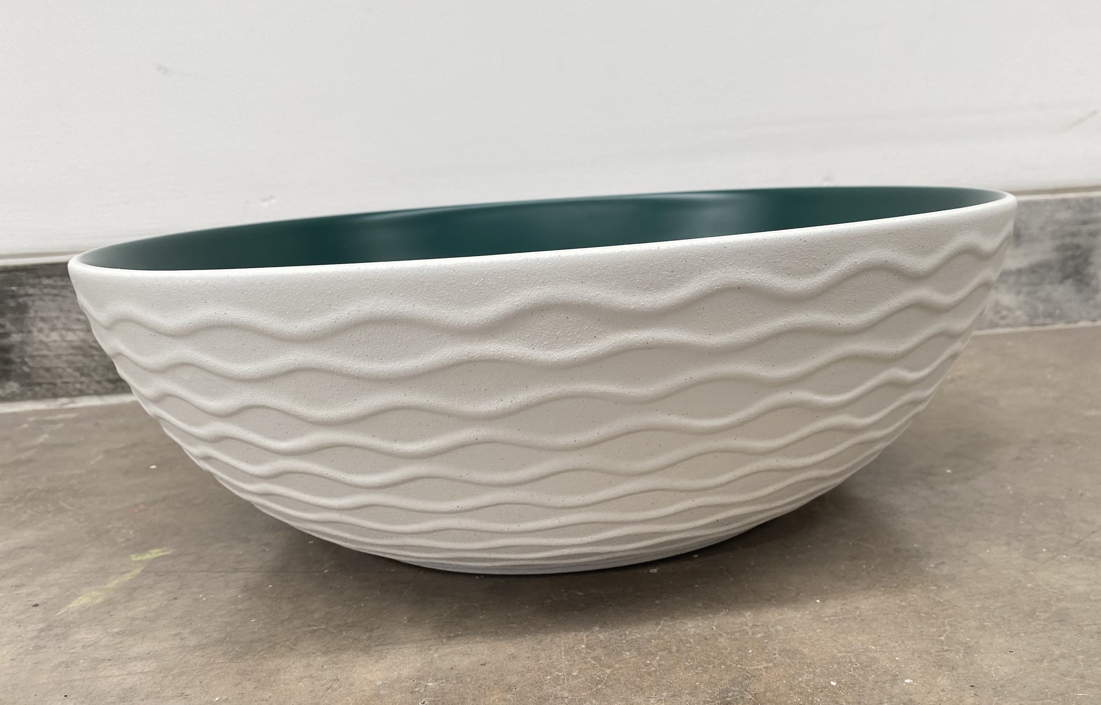 Lavabo Cerámico para Baño KAU, forma redonda color en el exterior blanco mate con textura en alto relieve y acabado rústico, esmalte verde en el interior. De sobreponer con diseño europeo ideal para todo tipo de baños. Dimensiones 400x400x135 mm