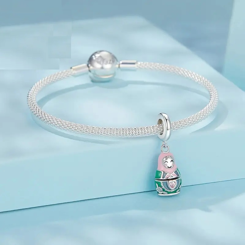 Dije Matryoshka tipo pandora plata 925 con baño de oro blanco